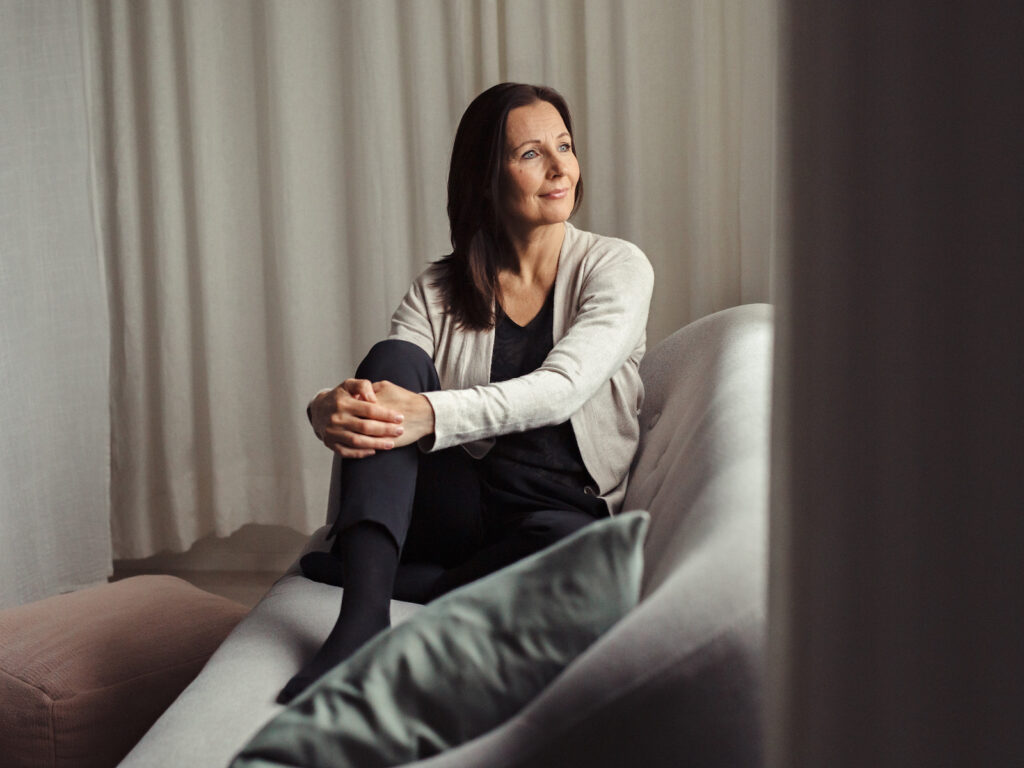 Kognitiivinen lyhytterapeutti Piia Pihlajamaa rentoutuneena rauhallisessa sisätilassa